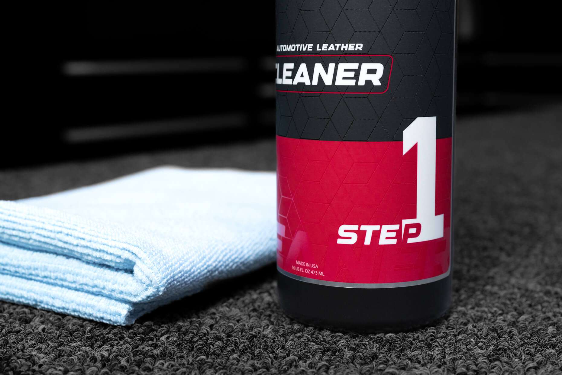 16oz bottle of Sanctum automotive leather cleaner with microfiber towel - close view of Step 1