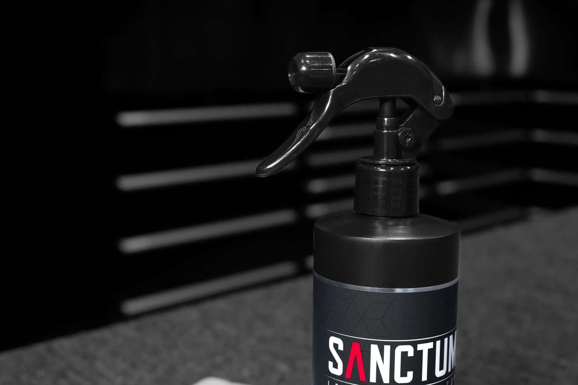 16oz bottle of Sanctum automotive leather cleaner with microfiber towel - close up of sprayer nozzle