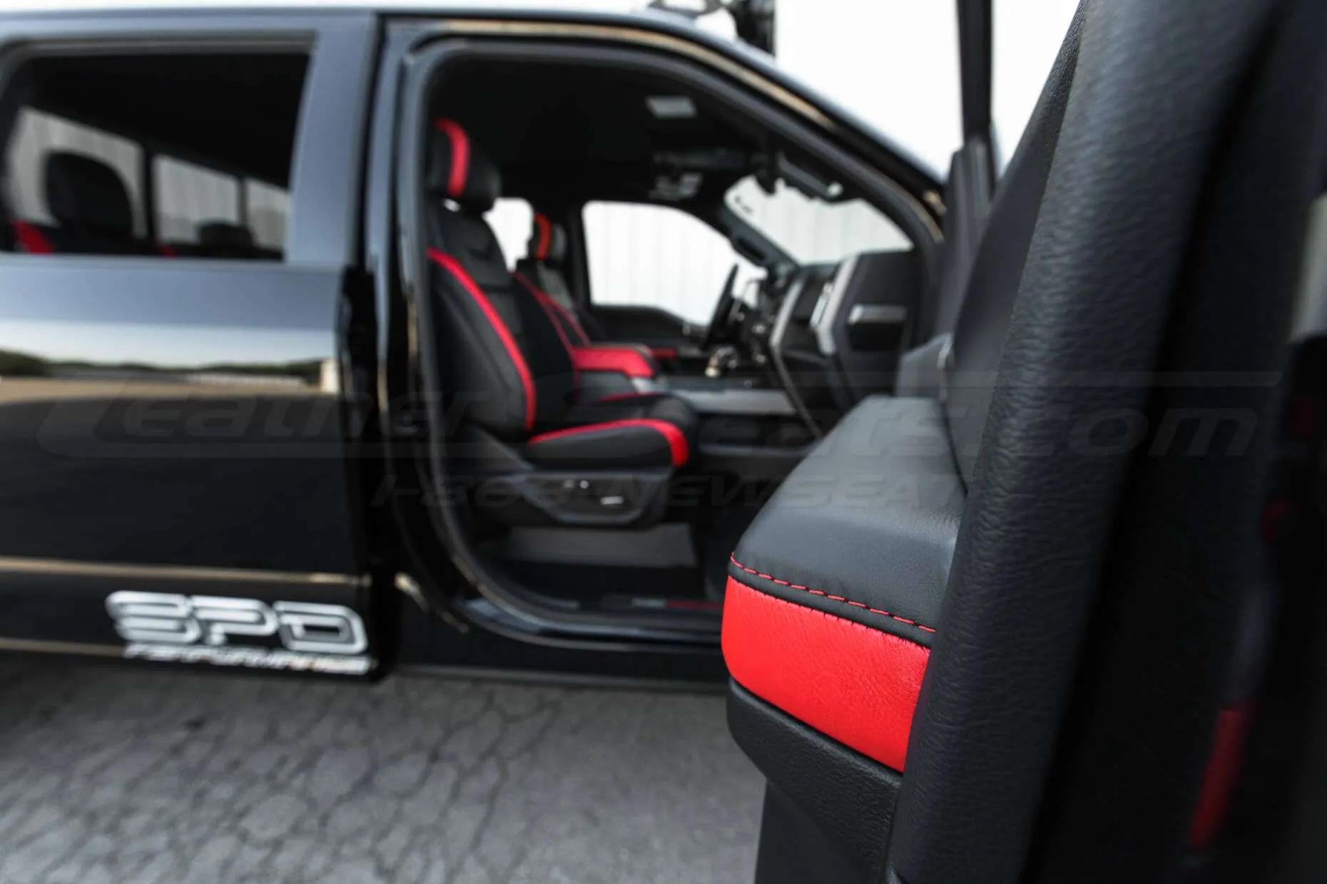 Ford Raptor installed upholstery kit - Black & Bright Red - Armrest with interior in the background