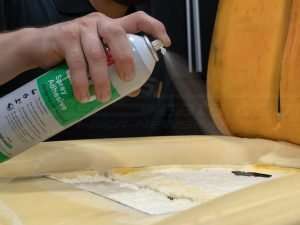 Spraying Adhesive down to help the Carbon Fiber pad to stick