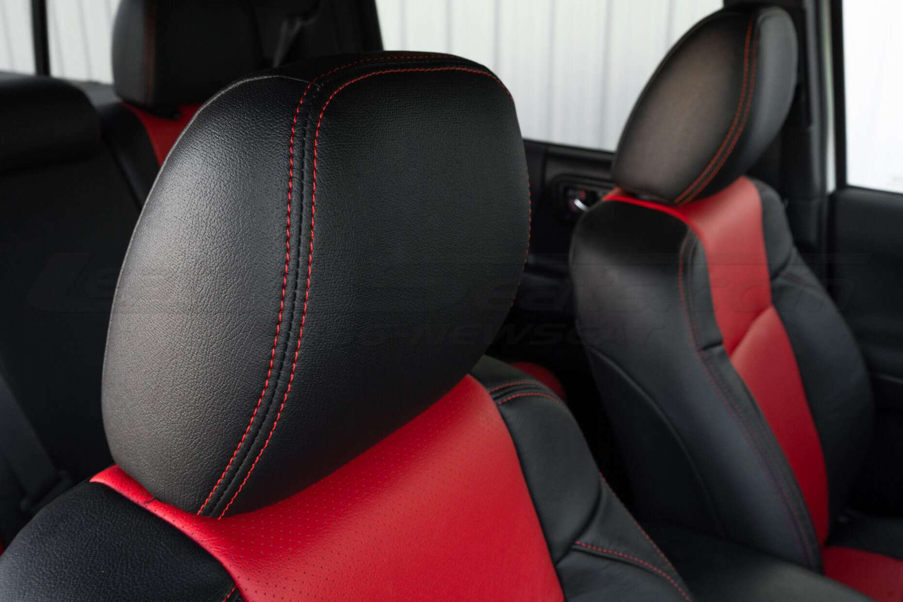 Black leather headrest with bright red contrast stitching