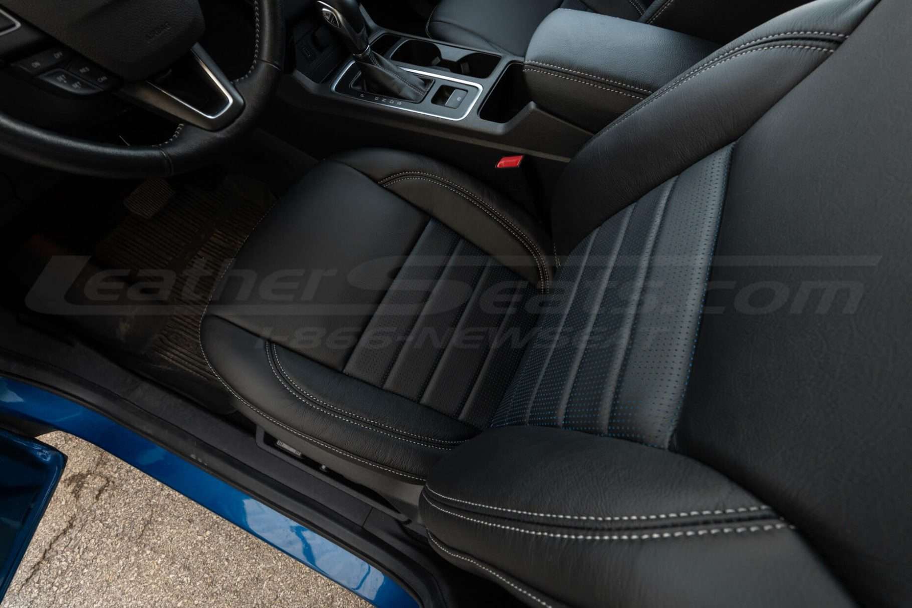 Top-down view of front driver seat installed with Blue Piazza Inserts