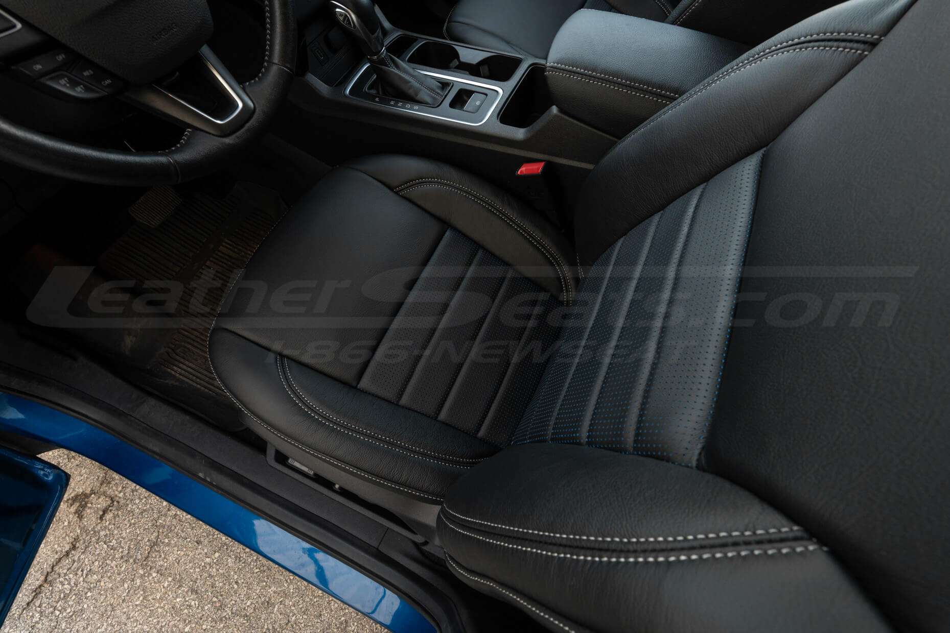 Top-down view of front driver seat installed with Blue Piazza Inserts