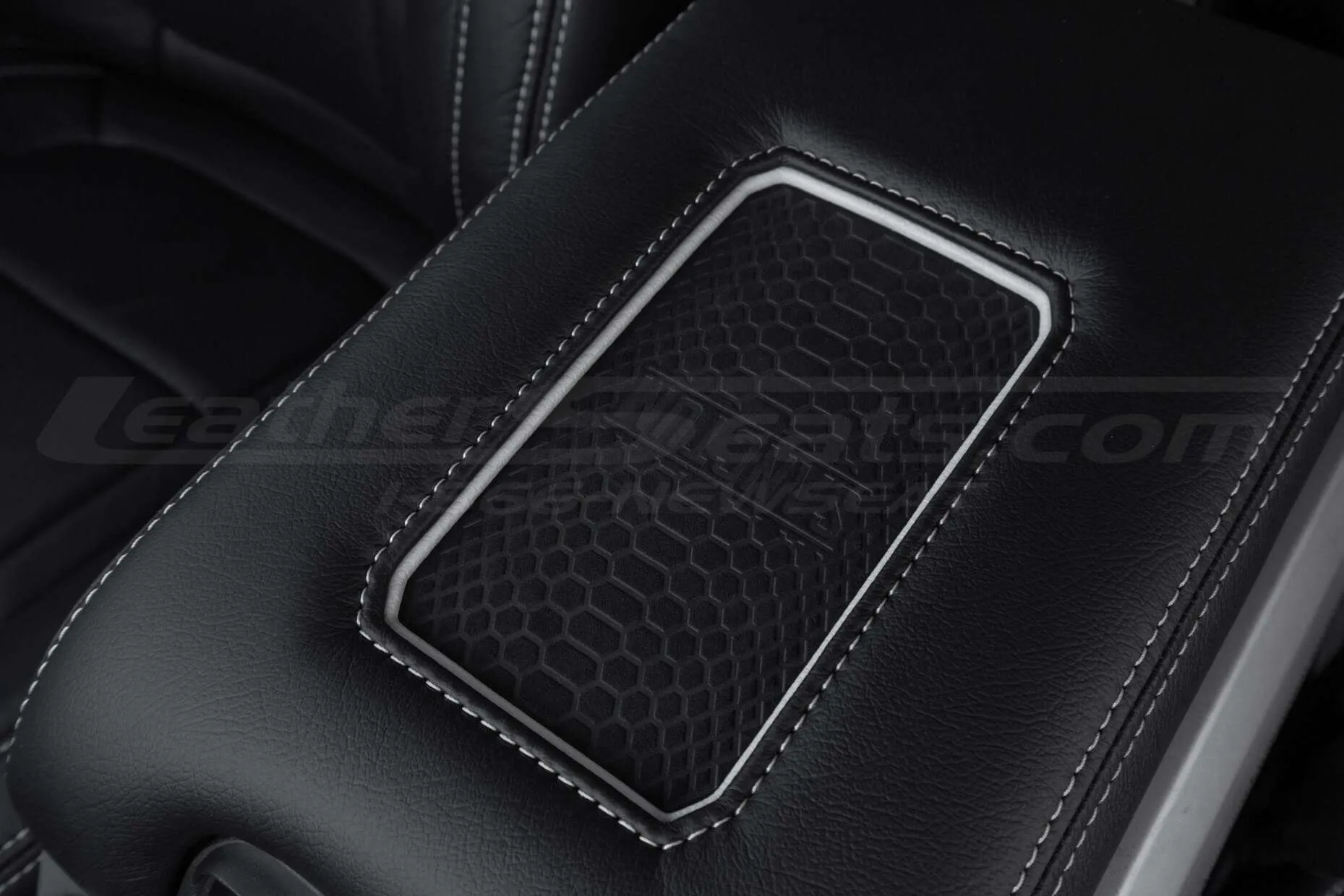 Phone charging pad close-up on leather center console lid
