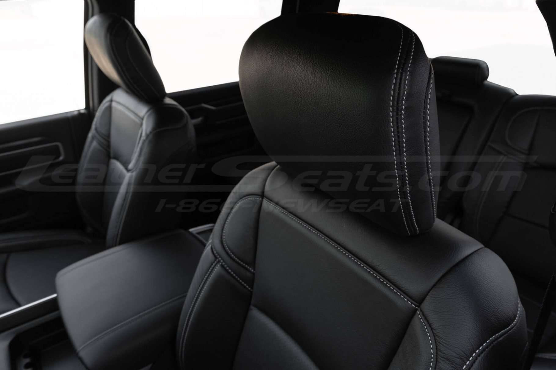 Aftermarket black leather headrest cover with contrasting silver double-stitching installed