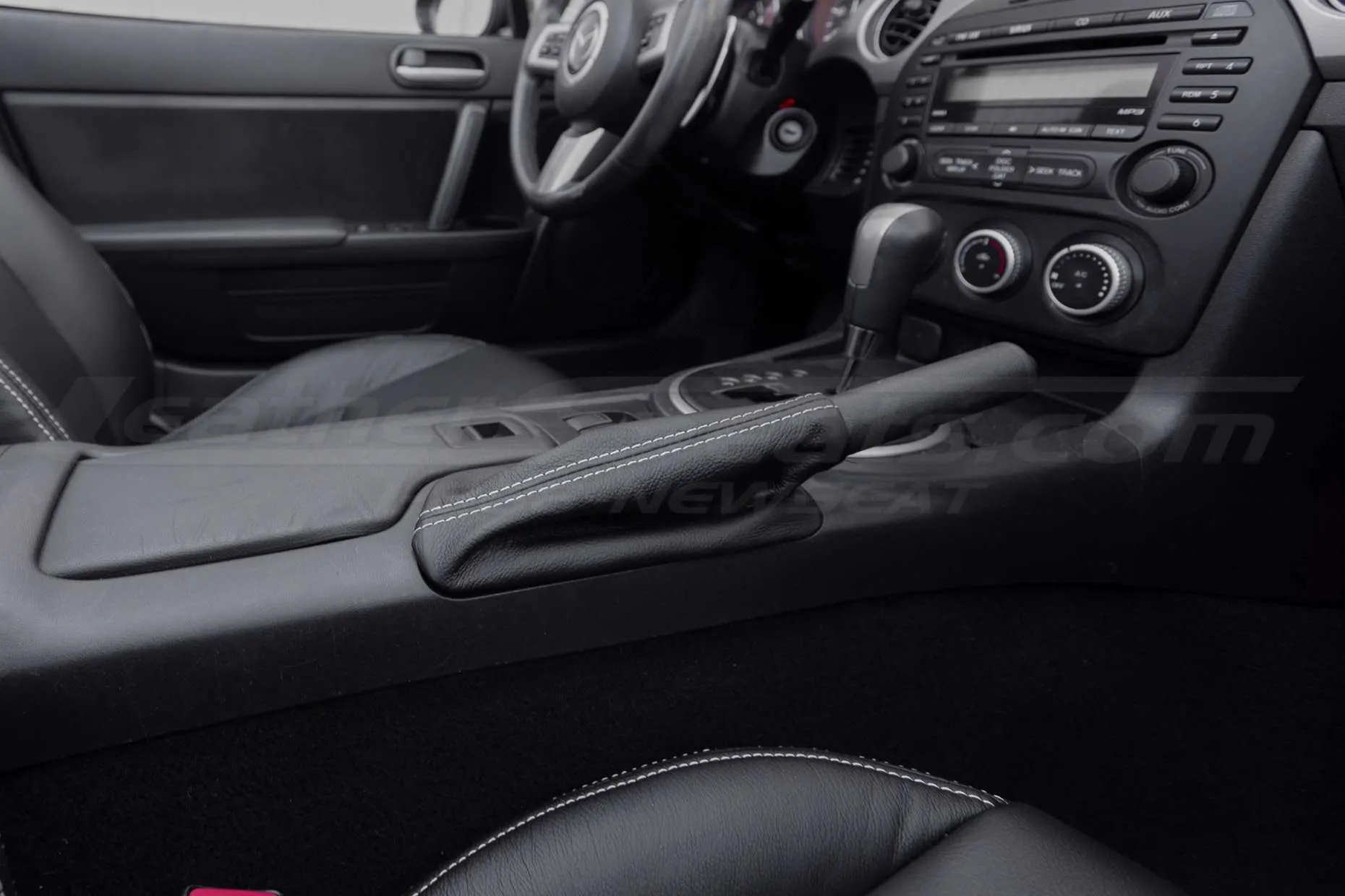 Black leather Mazda Miata hand brake upholstery with contrasting White stitching