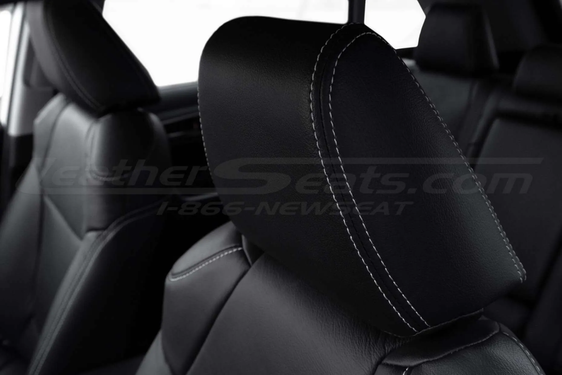 Black leather installed headrest with contrasting double-stitching in Dove Grey close-up
