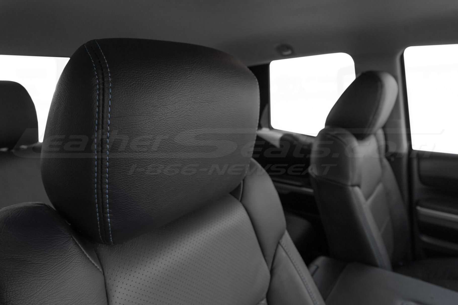 Black leather headrest close-up with contrasting double-stitching in Cobalt