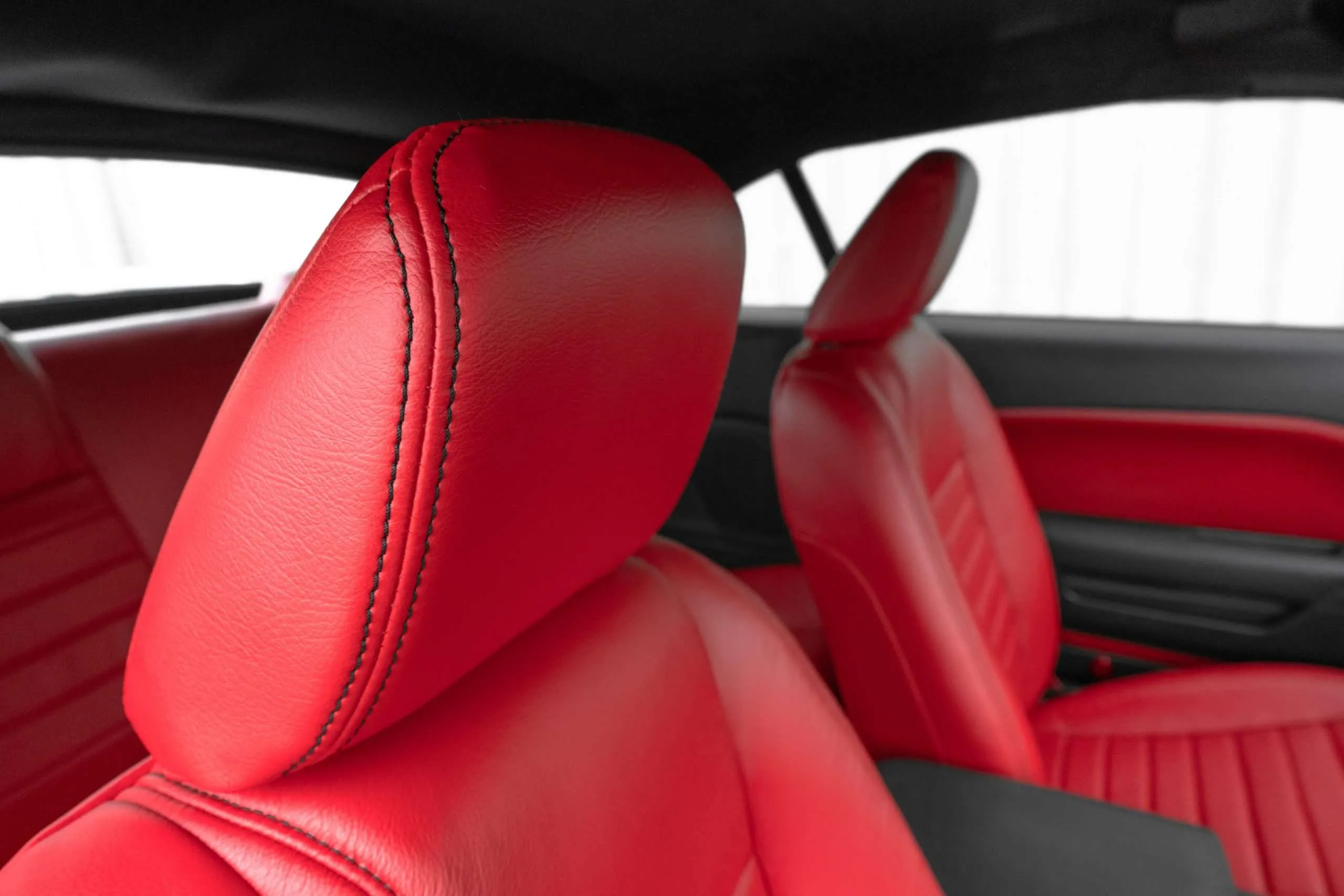 Installed leather headrest closeup with contrasting Black double-stitching