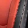 Contrasting double-stitching in Tangerine on Black leather - close-up