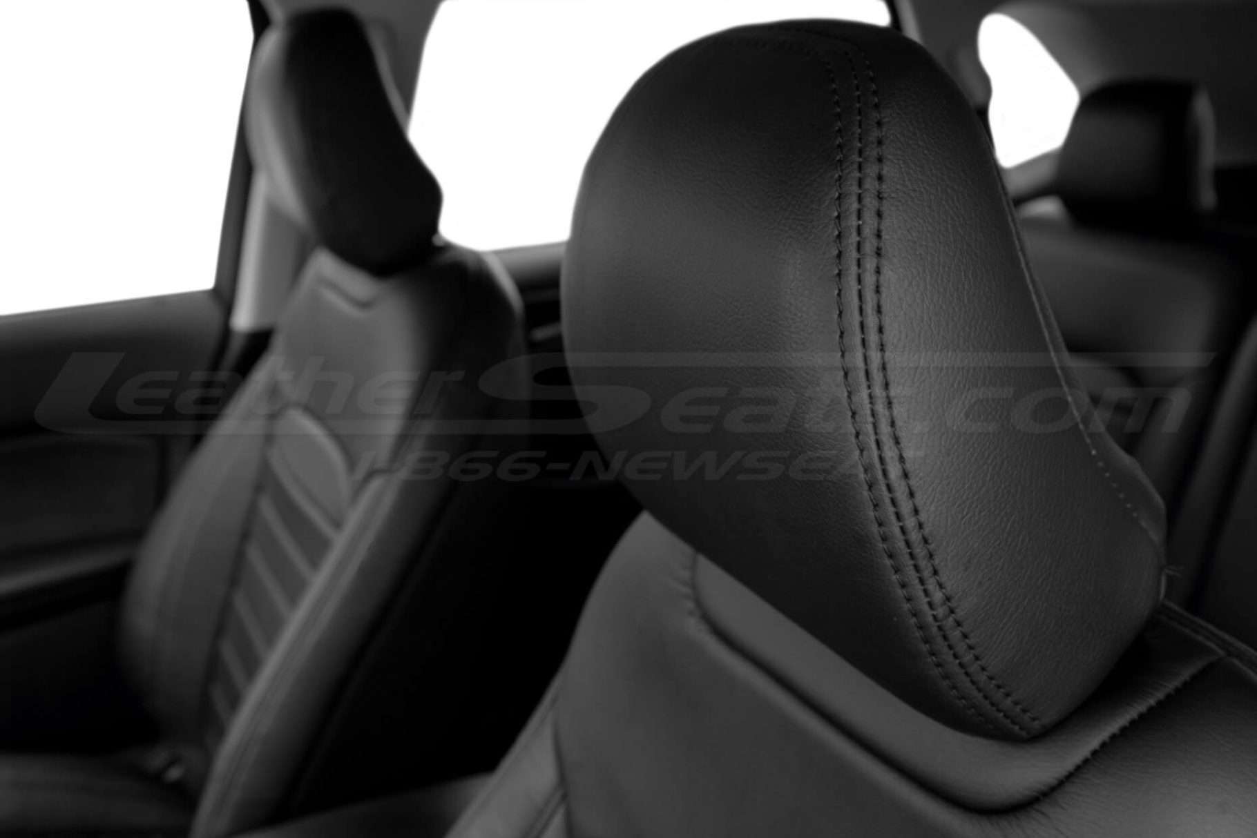 Black leather headrest close-up with matching black doubl-stitching