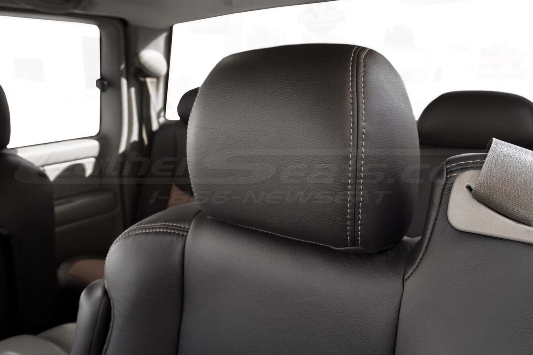 Black leather headrest close-up with contrasting desert sttching