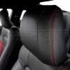 Black leather headrest close-up with bright red stitching