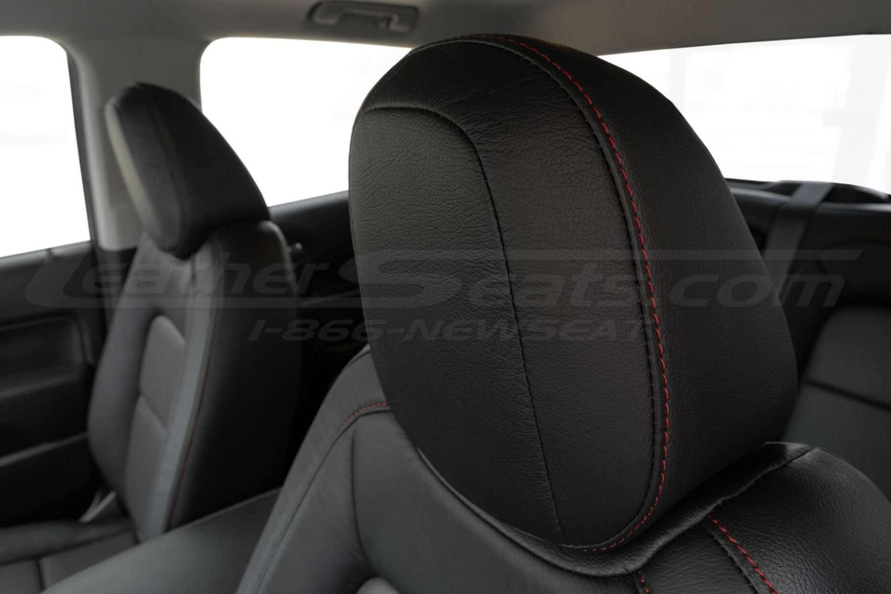 Black leather headrest close-up with contrastin gstitching in Cardinal
