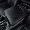 Driver side close-up of Ford F-150 black leather console lid cover with ston stitching
