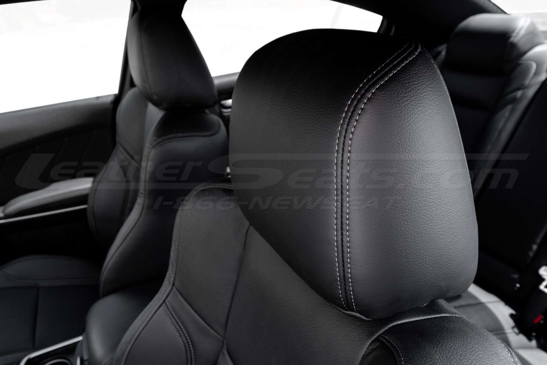 Contrasting Grey stitching on Black leather headrest c;ose-up