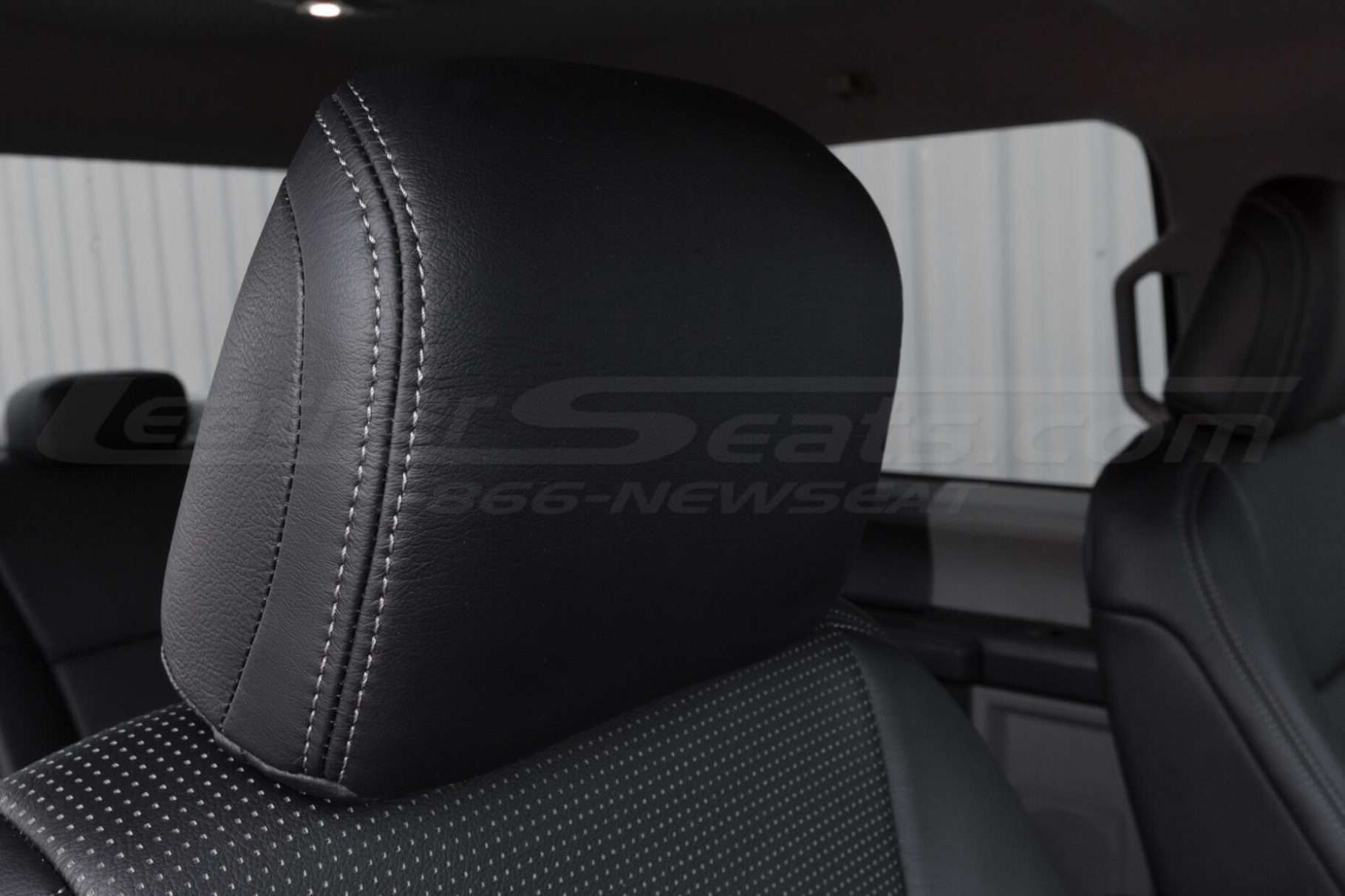 Black leather headrest close-up with contrasting Platinum stitching