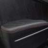Close up of leather door armrest upholstery in blck leather with red stitching