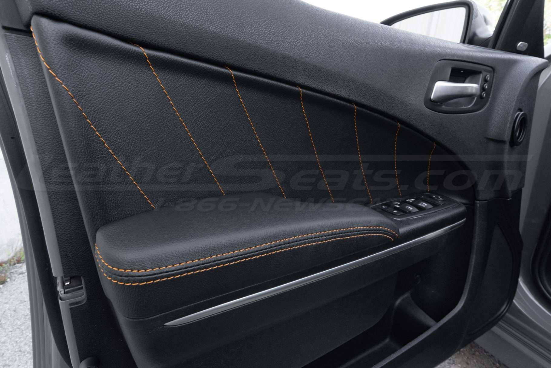 Black leather door inserts and armrests with contrasting orange stitching for dodge charger sedan