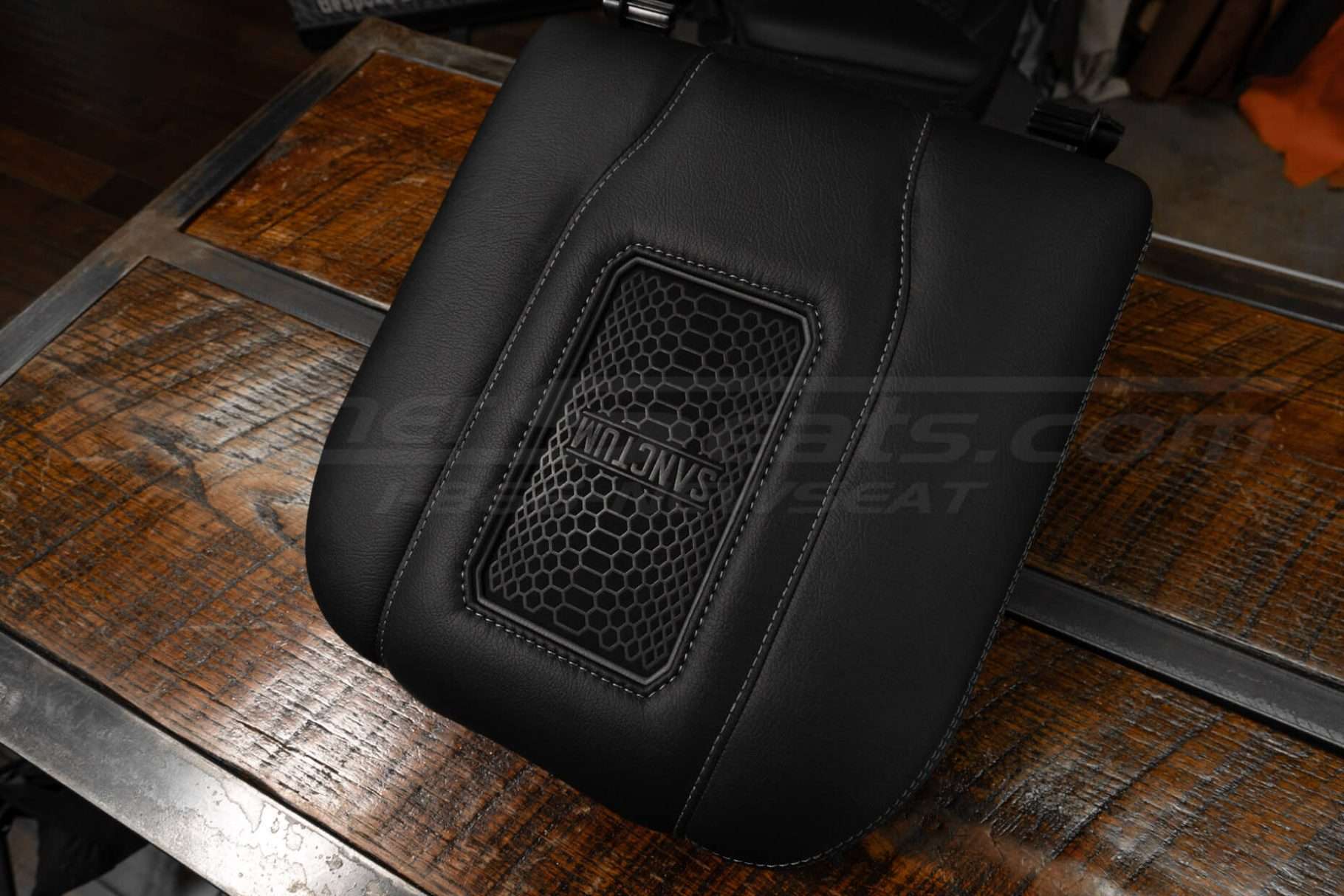 Black leather wireless charging center console lid with grey stitching