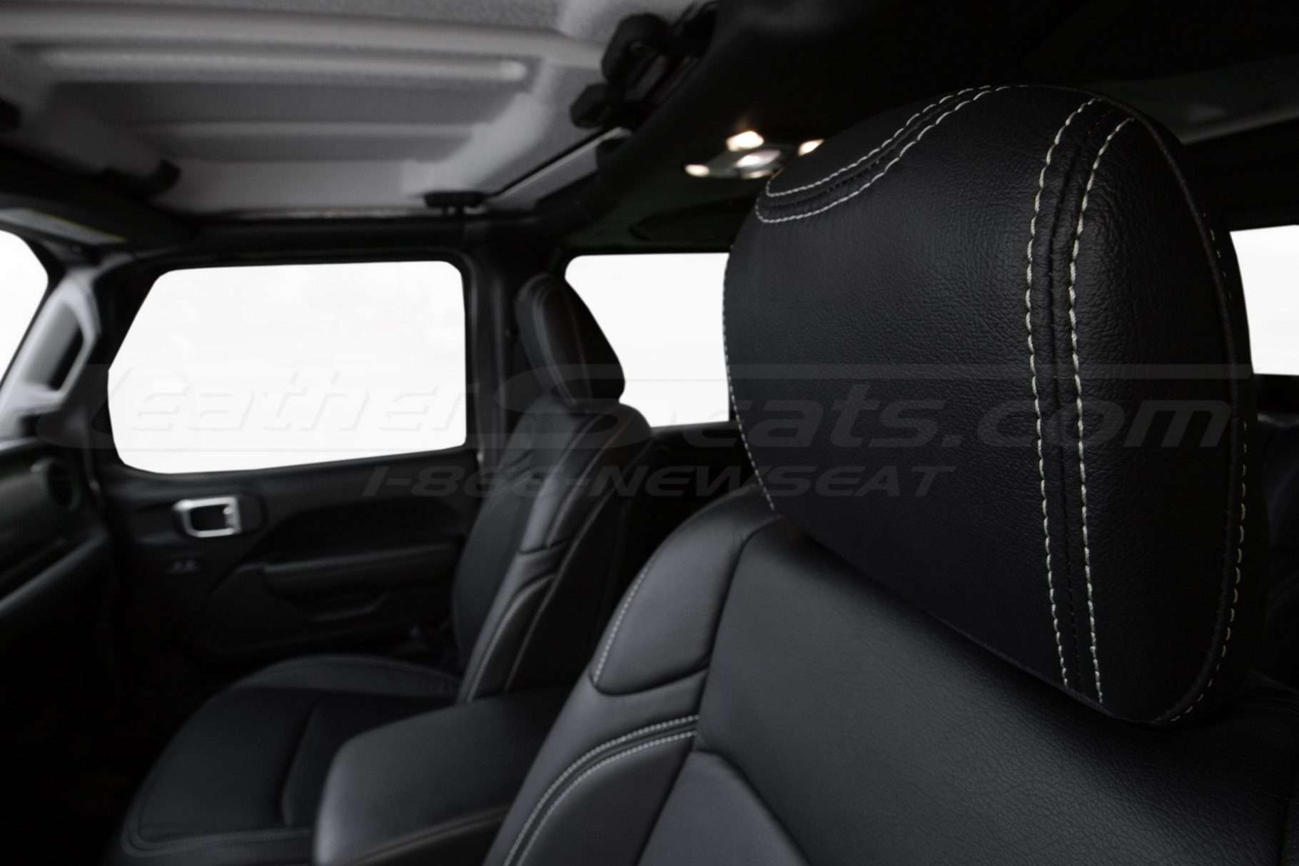 Black leather headrest close-up with constrasting ice grey stitching