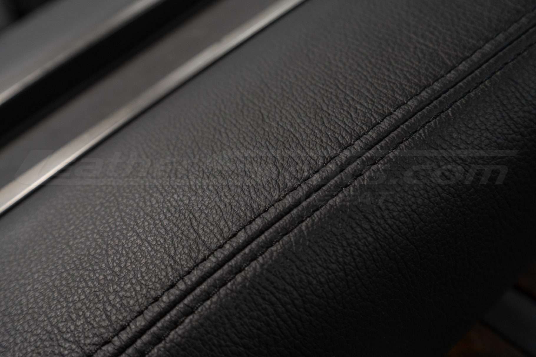 Black double-stitching on black leather console cover