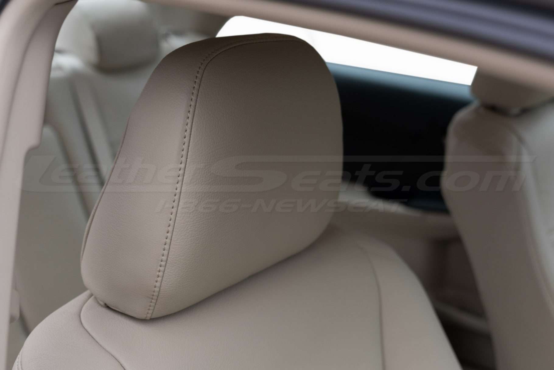 installed leather headrest with matching ivory stitching close-up