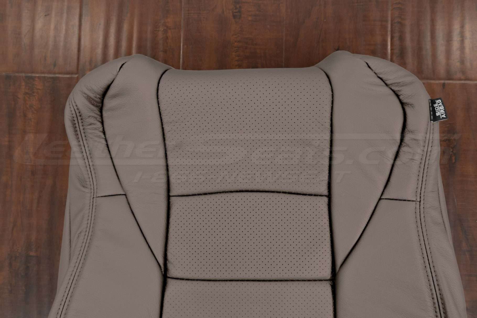 Upper section of leather backrest upholstery with perforated body sectiond