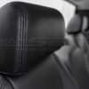 Installed black leather headrest close-up with matching black double-stitching
