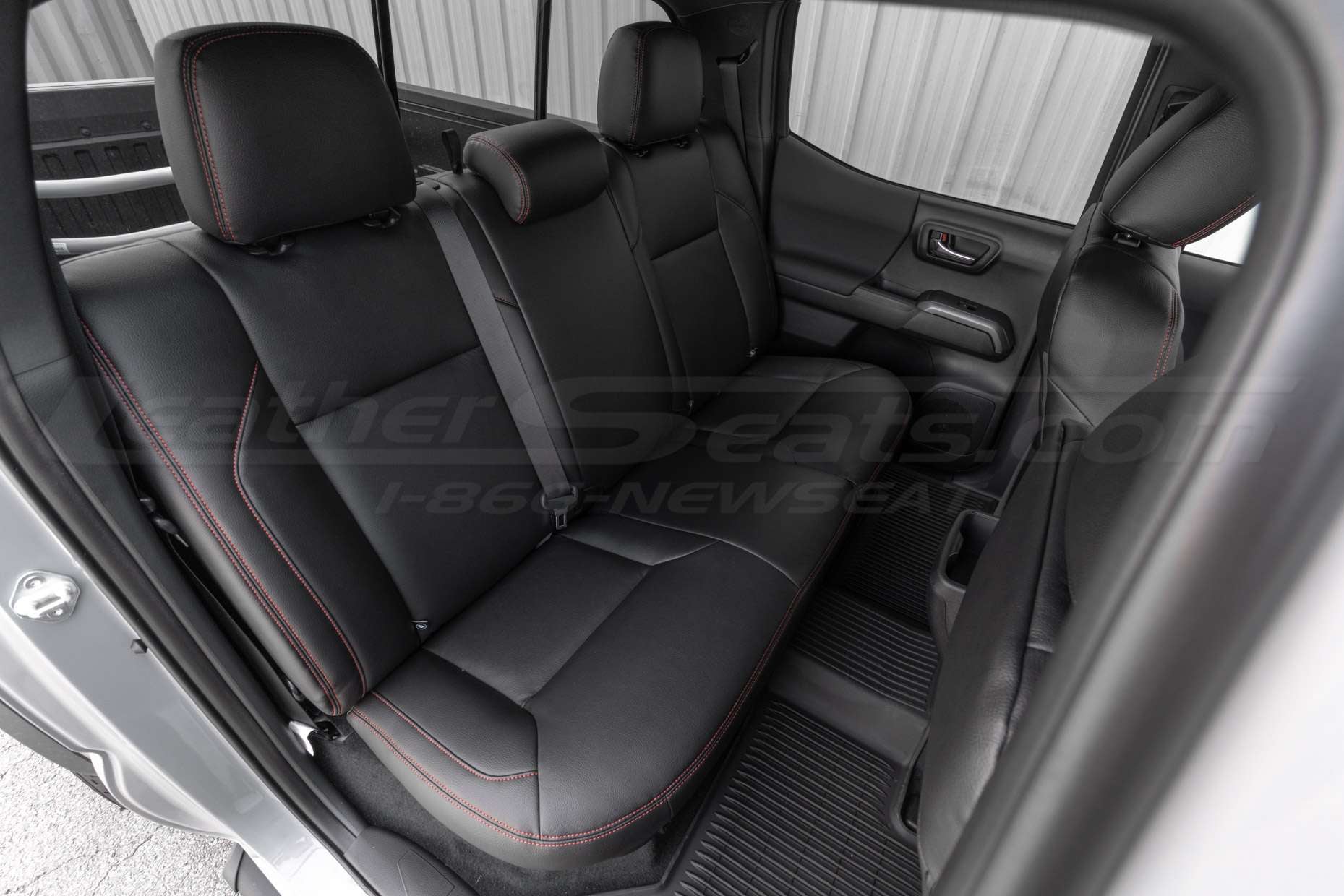 Tacoma double cab with installed black leather seats and bright red stitching - Rear seats passenger side