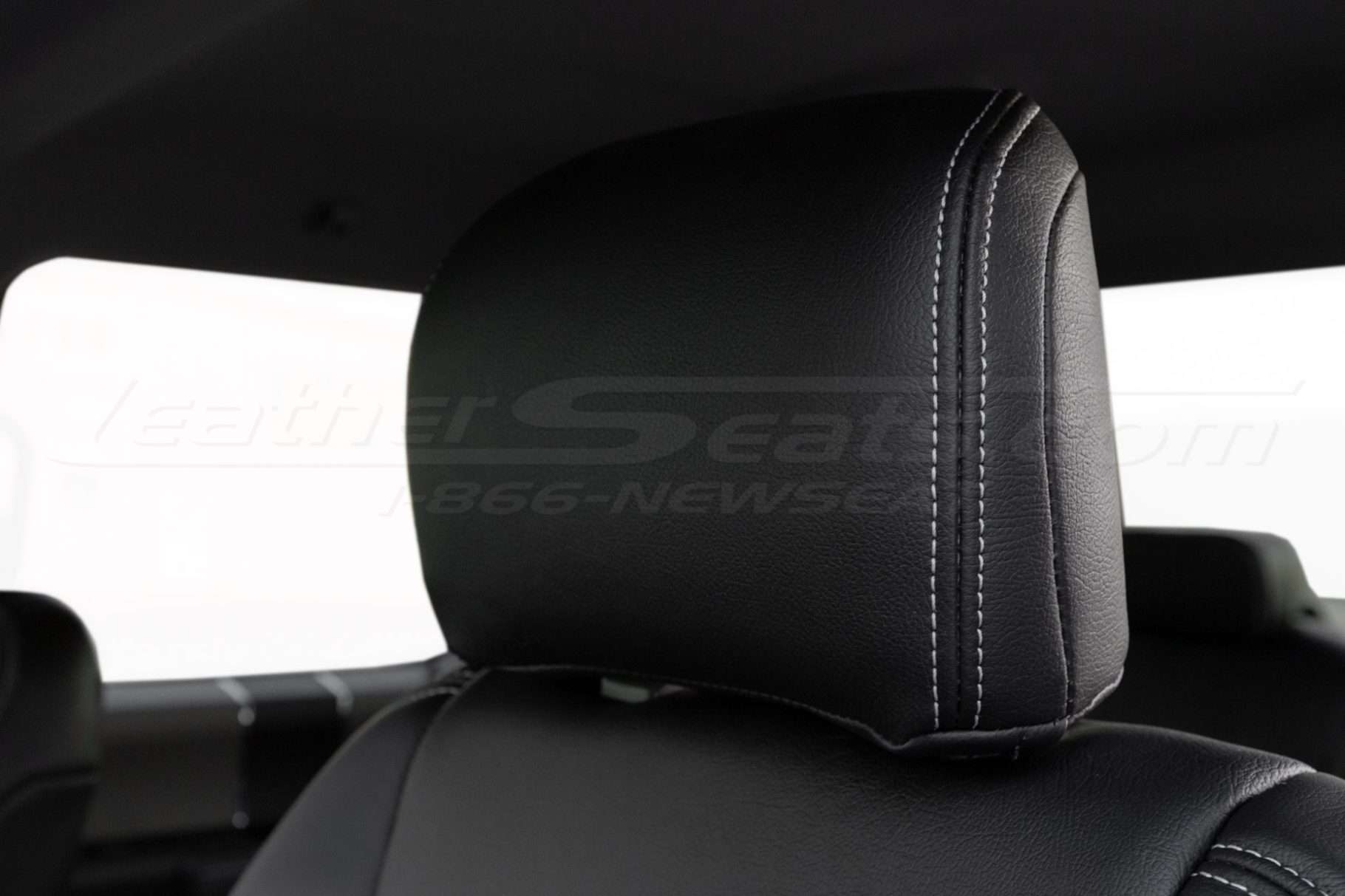 Installed black leather headrest with contrasting silver stitching