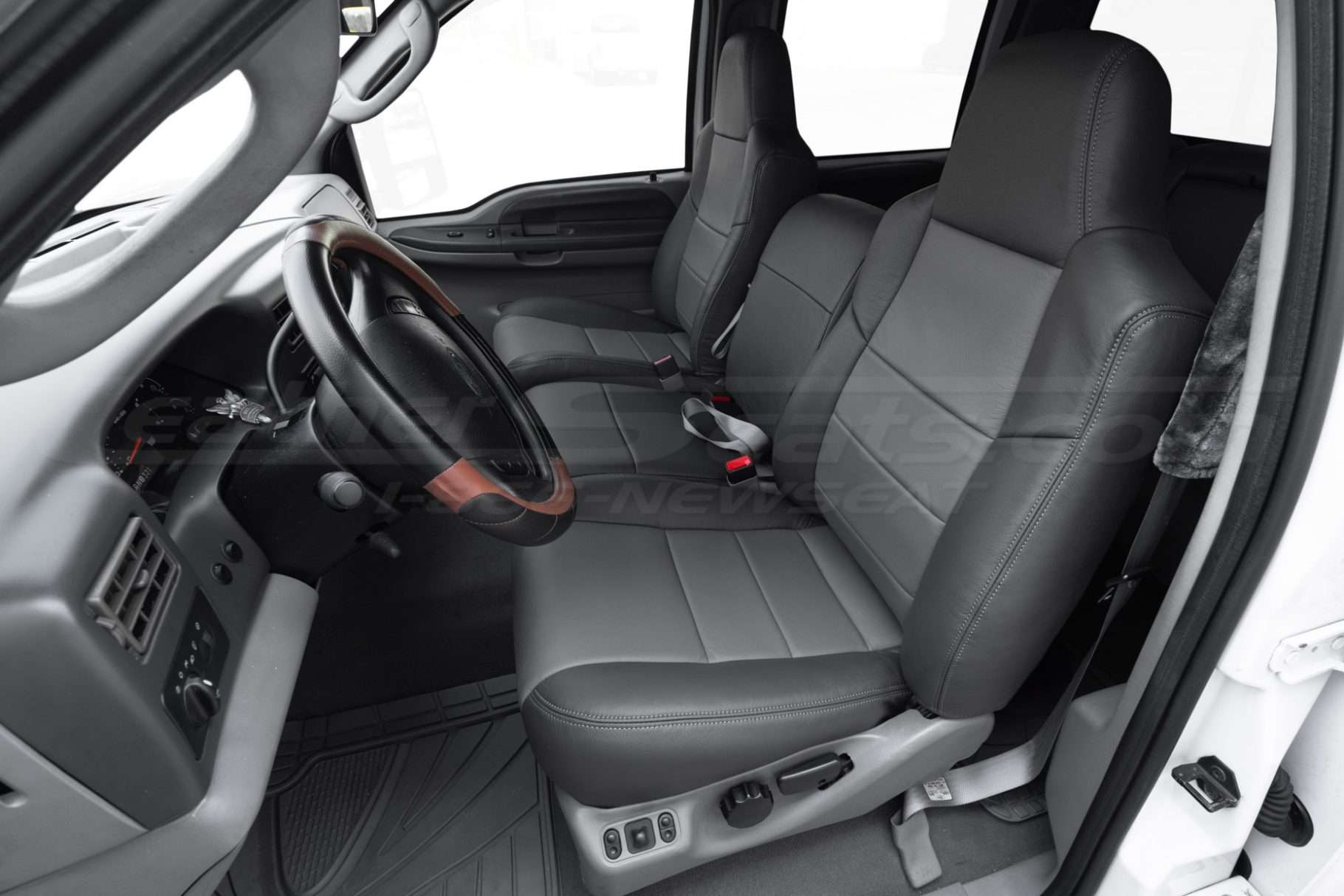 Ford Superduty aftermarket leather seat covers installed - Front driver seat with middle jump seat in sitting position
