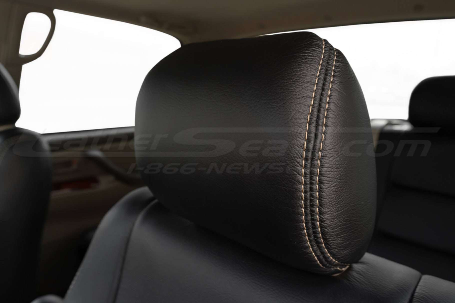 Black leather headrest with contrast adobe double-stitching close-up