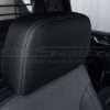 Installed black leather headrest with contrasting charcoal stitching
