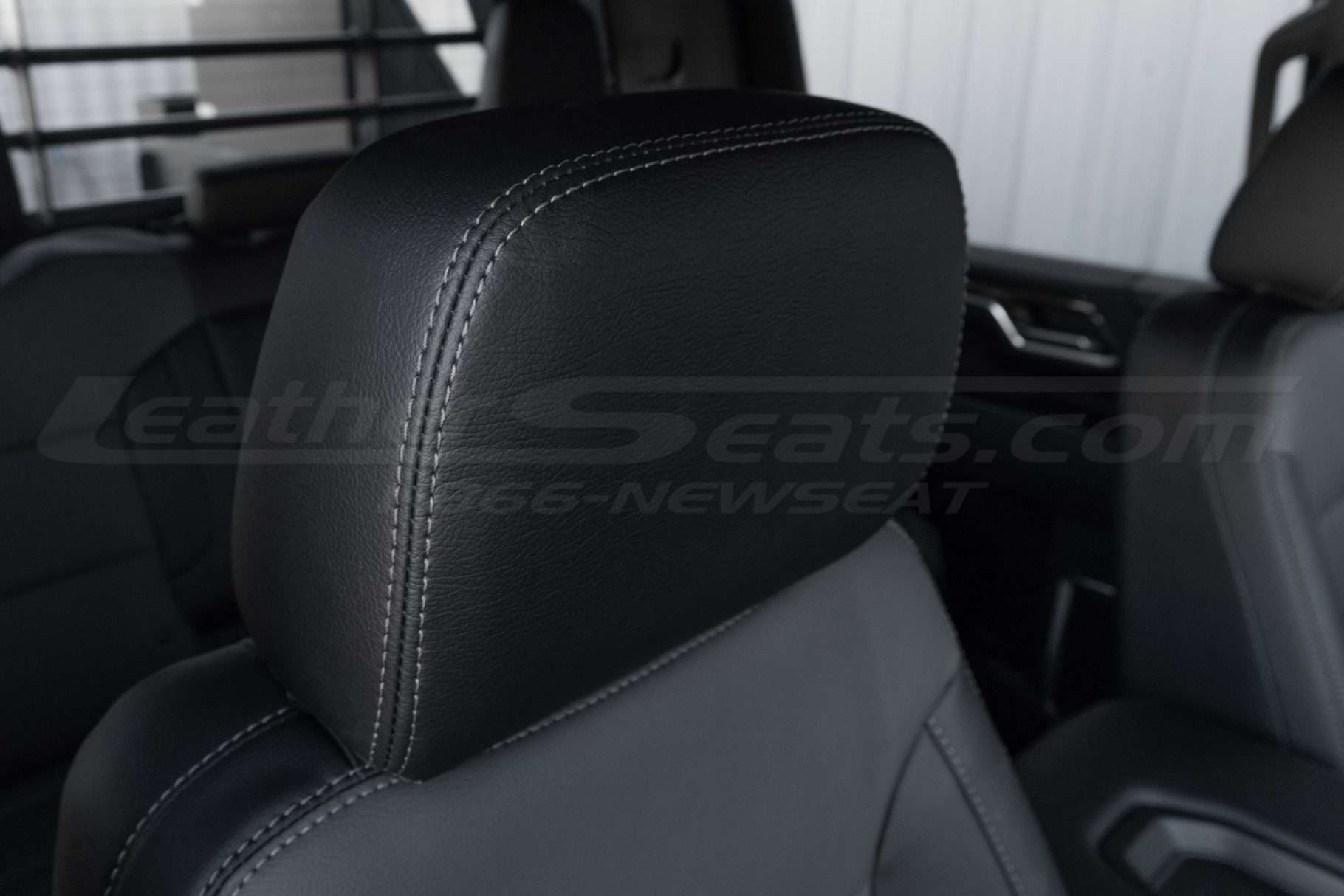 Installed black leather headrest with contrasting charcoal stitching
