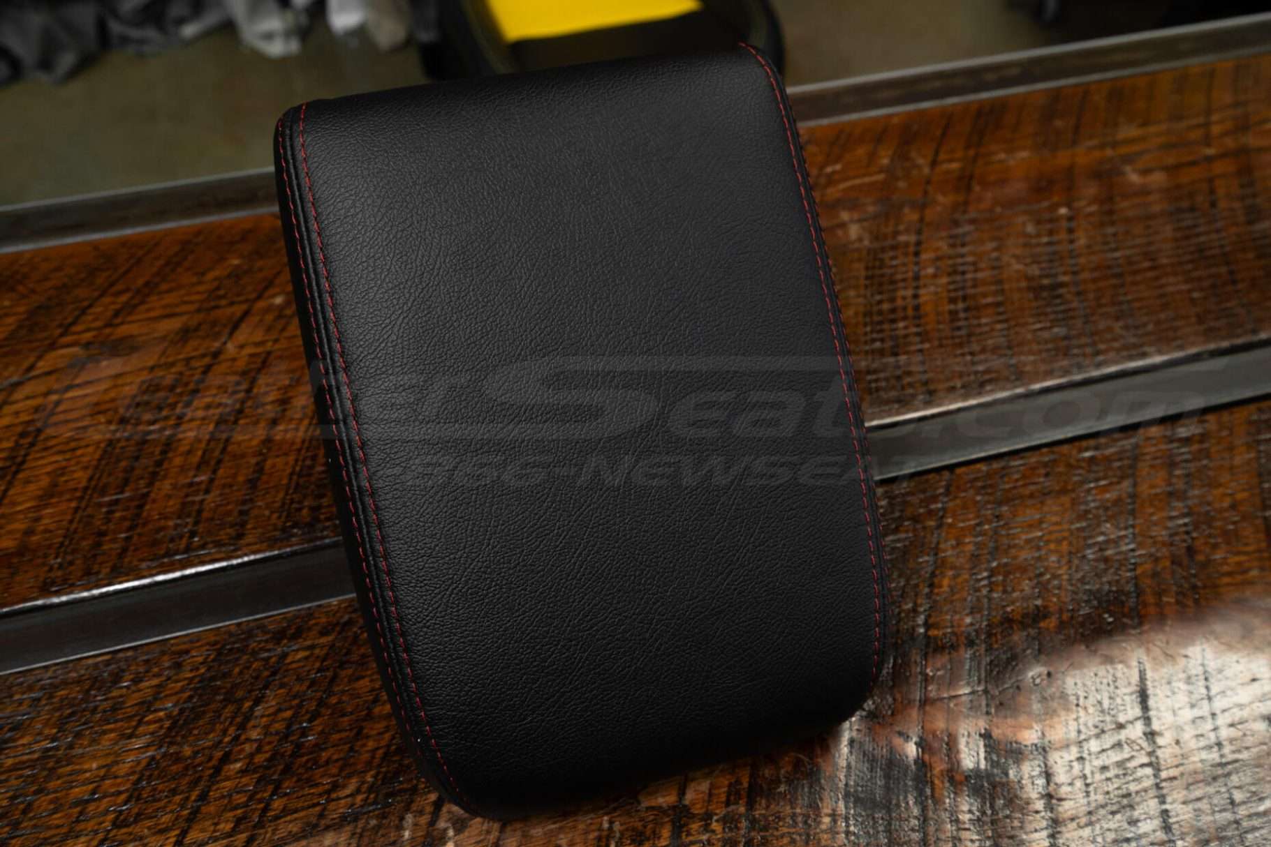 Top-down side view of aftermarket leather console lid cover for Toyota Tacoma