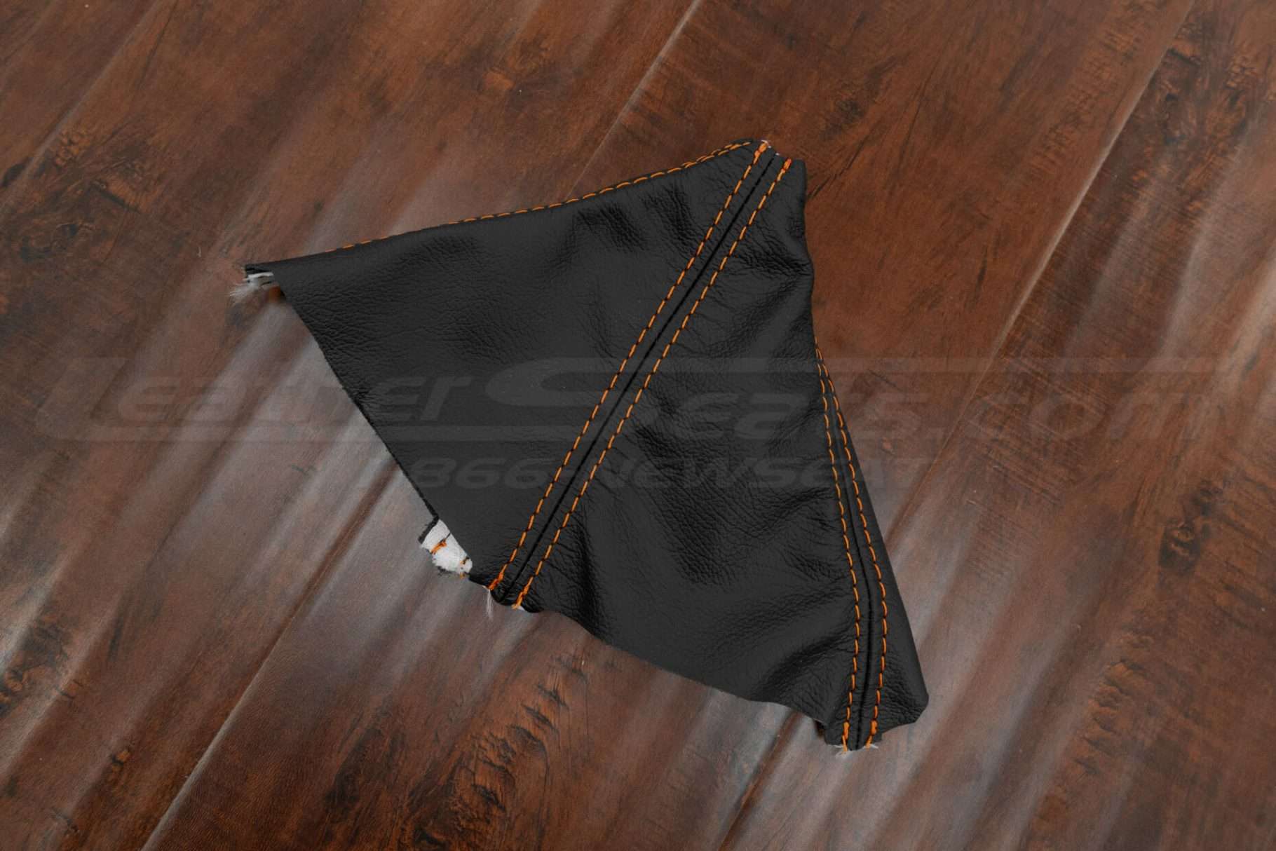 Top-down side view of Dodge Challenger leather shift boot upholstery in black with orange stitching