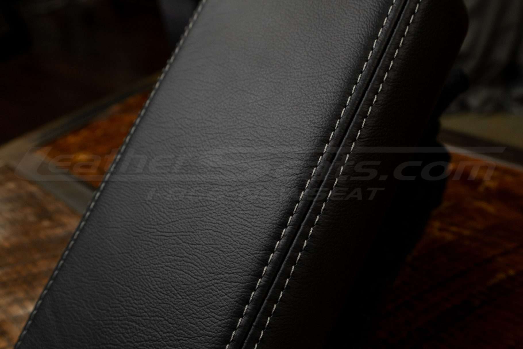 Contrasting frost stitching on black leather console lid cover