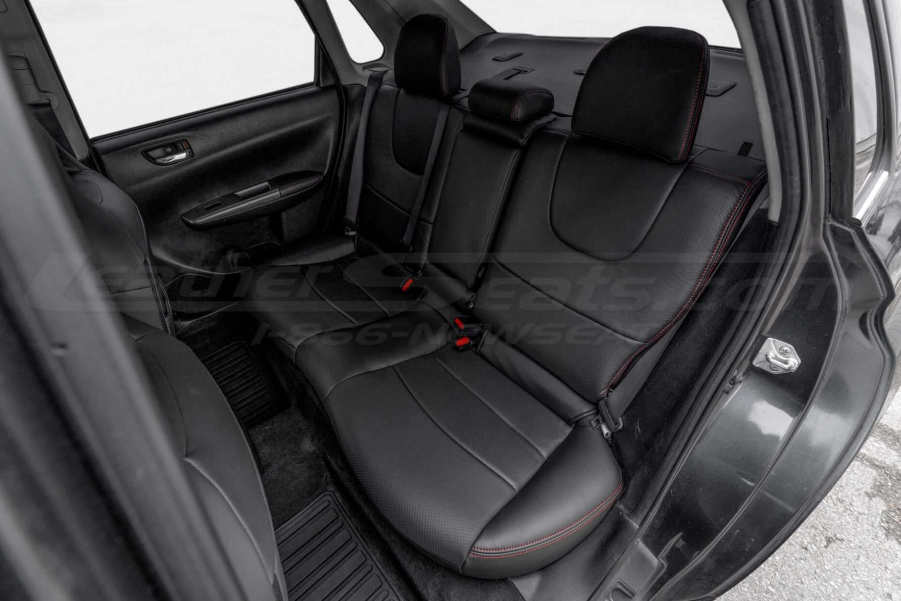 Driver side view of installed black leather rear seats in Subaru Impreza