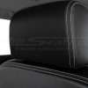 Black leather headrest cover close-up with contrasting silver stitching