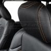 Black leather jeep headrest close-up with contrast orange stitching