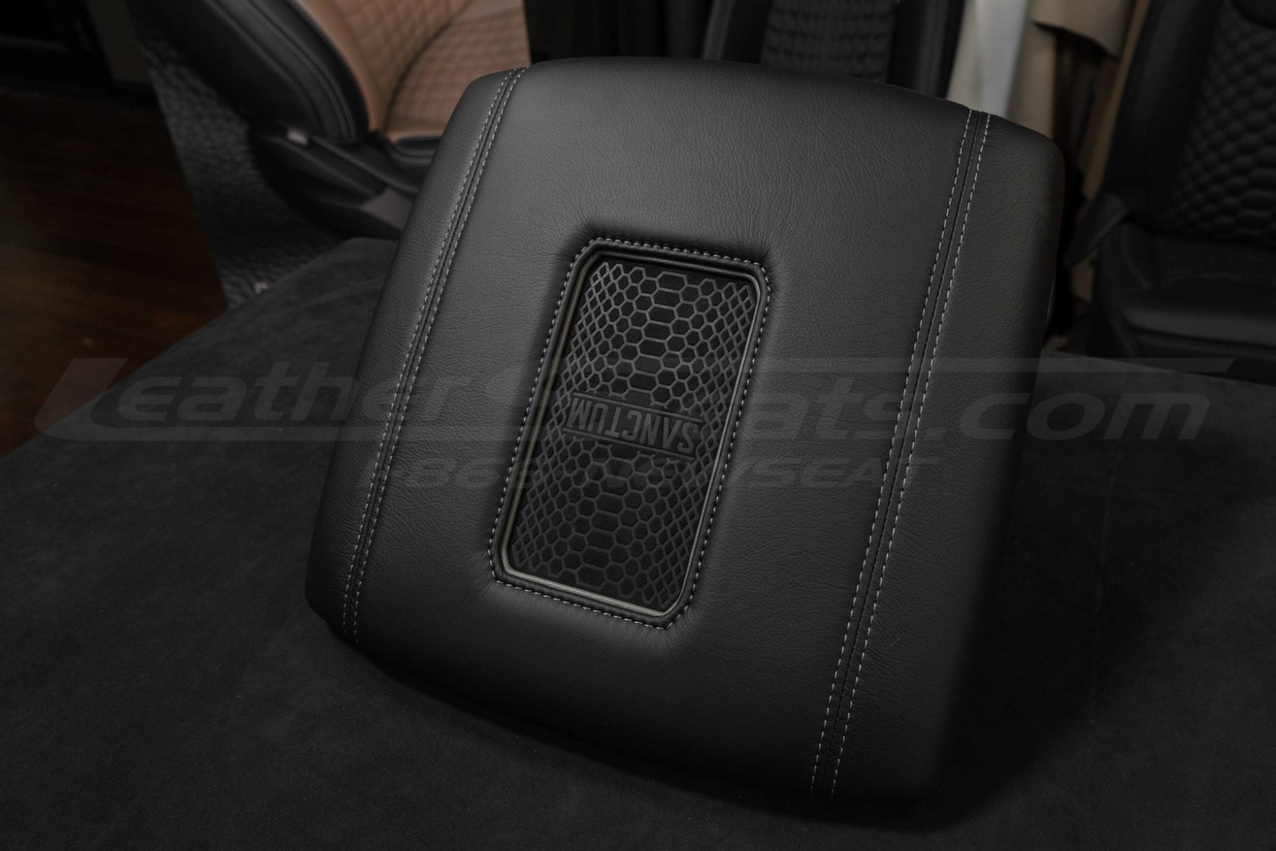 Low side view of qi2 charging console lid in black leather with smoke stitching and trim ring