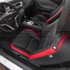Driver's perspective inside a Camaro, highlighting the black and red sport seats and steering wheel