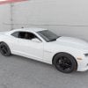 Side profile of a white Chevrolet Camaro, showcasing its sleek design