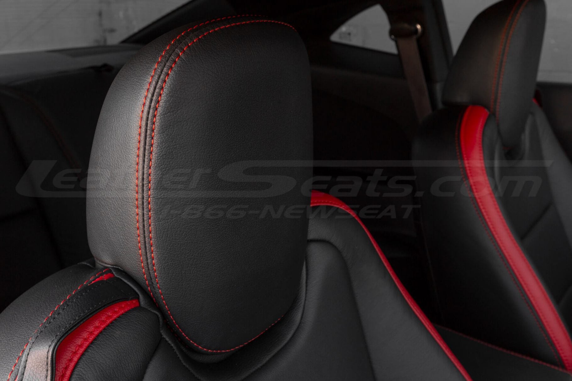 Close-up of Chevrolet Camaro black leather headrest with red stitching