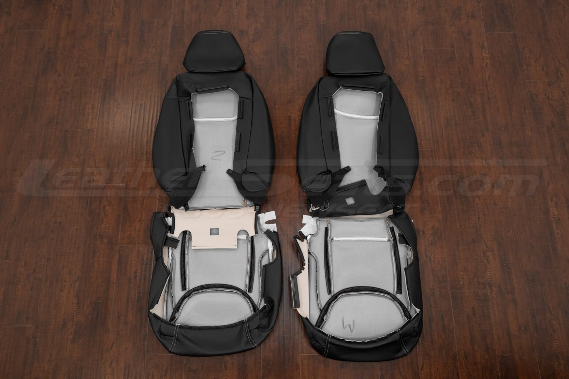 Underside view of 2011 Chrysler 300C seat covers, showing black and adobe leather upholstery with internal foam and frame structure