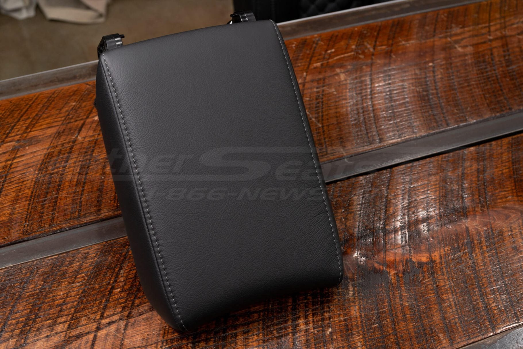 Aftermarket black leather console armrest lid with textured finish