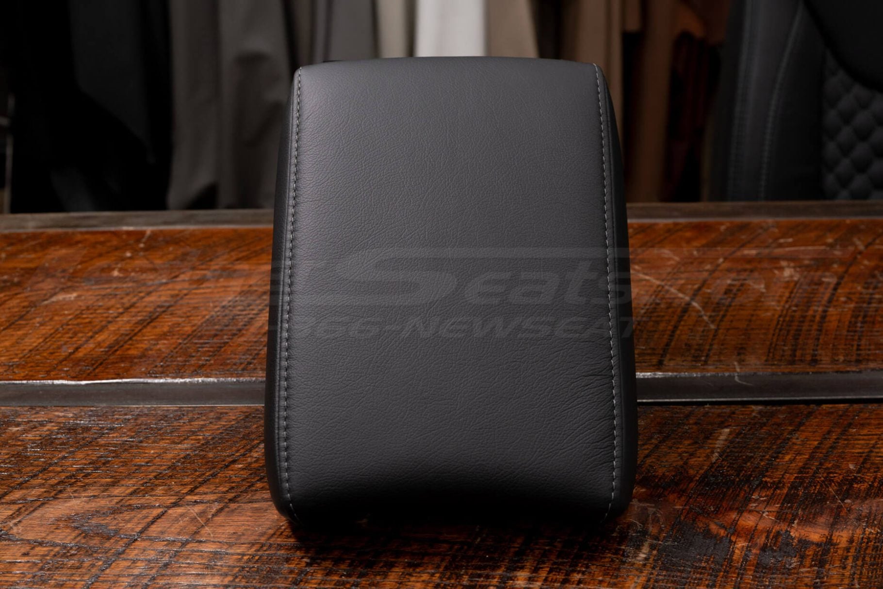 Premium leather CR-V console armrest cover displayed upright on wood grain surface.