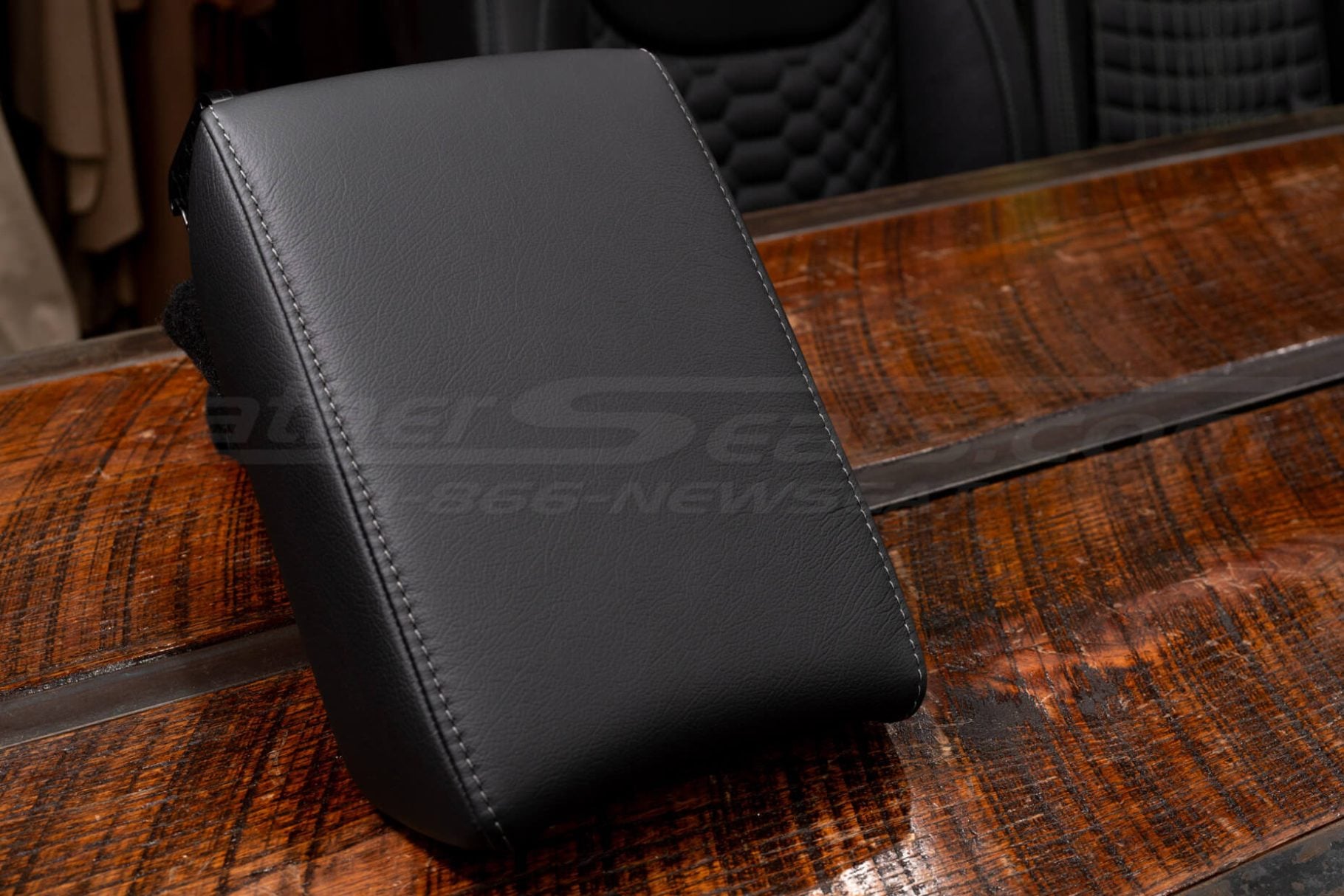Black leather console lid cover for 2017–2022 Honda CR-V on rustic wooden surface.