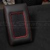 Top-down side view of black leather charging console lid with bright red stitching and bright red trim ring